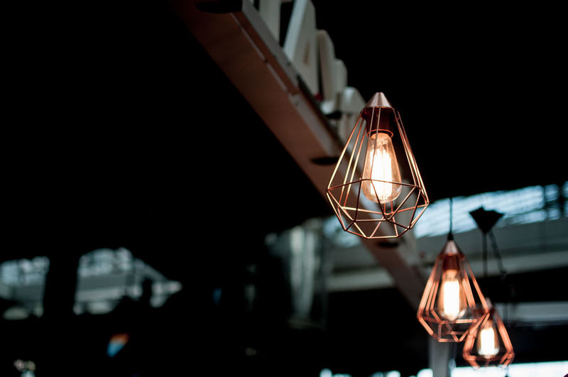 Low angle view of illuminated lamps hanging in cafe