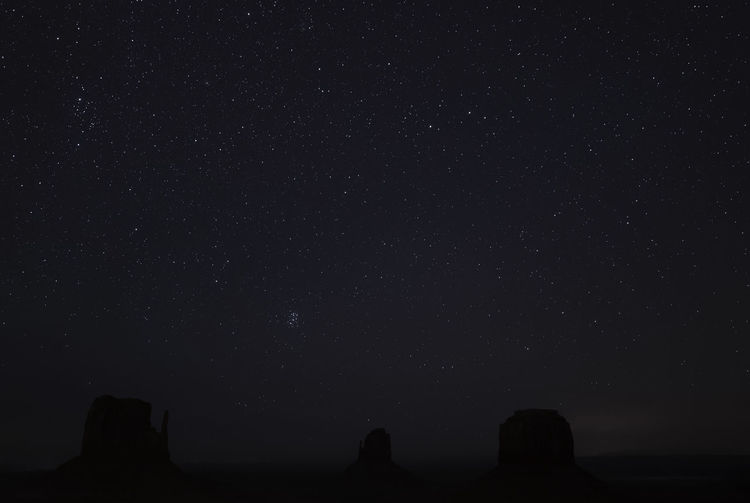 Low angle view of silhouette rocks against star field at night