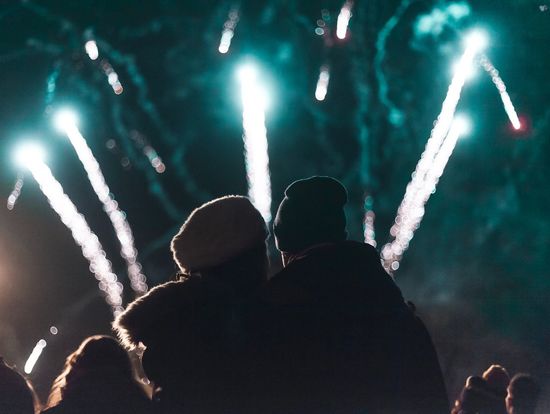 Rear view of couple looking at firework display