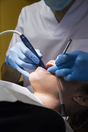Cropped image of dentist giving treatment to patient at medical clinic