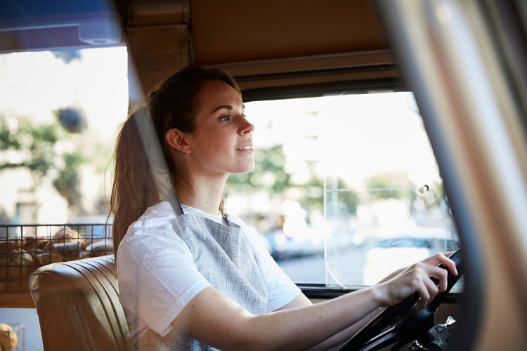Mid adult woman looking away while sitting in car