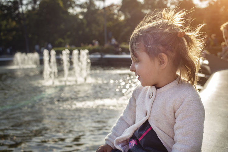 Girl sitting near fountain outdoors
