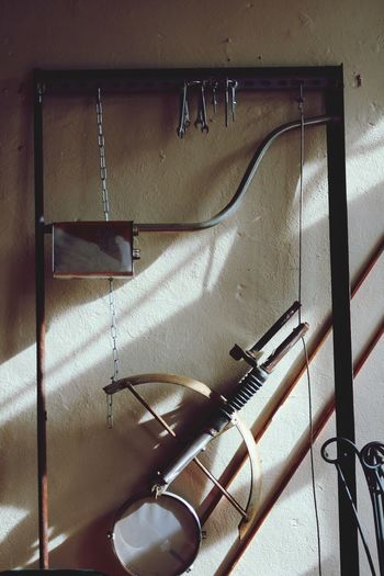 Close-up of bow and arrow hanging on wall