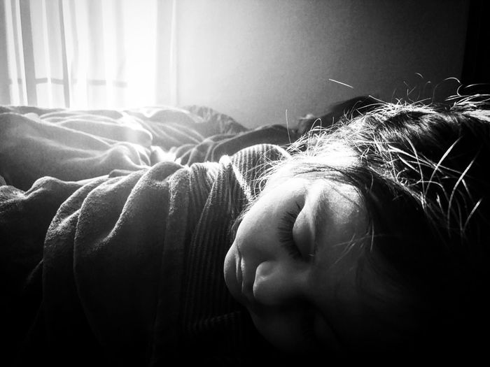 Close-up of girl sleeping on bed at home
