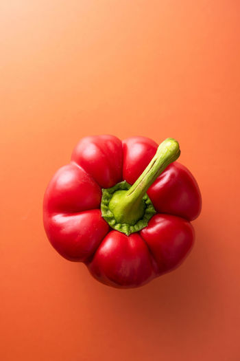 Close-up of red bell peppers against orange background