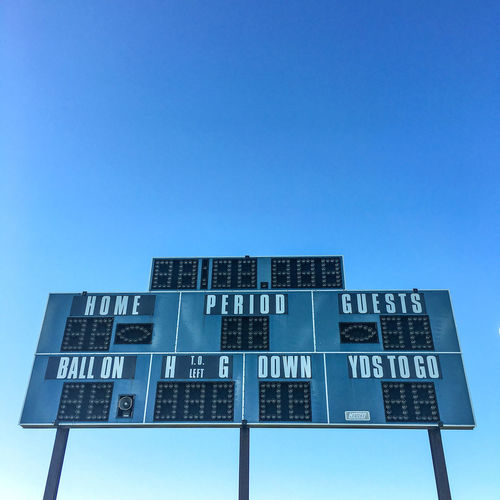 Low angle view of scoreboard against clear blue sky