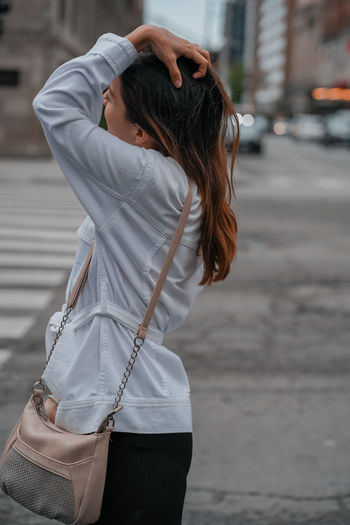 Rear view of woman standing on street