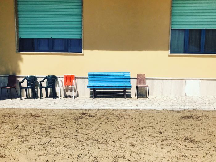 Multi colored chairs on beach against building