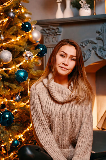 Young woman in illuminated christmas tree