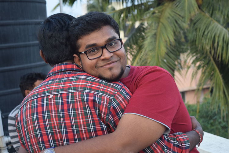 Portrait of young man hugging friend