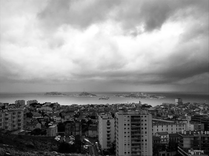High angle view of townscape by sea against sky
