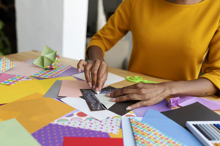 Origami artist sitting in studio folding colorful paper