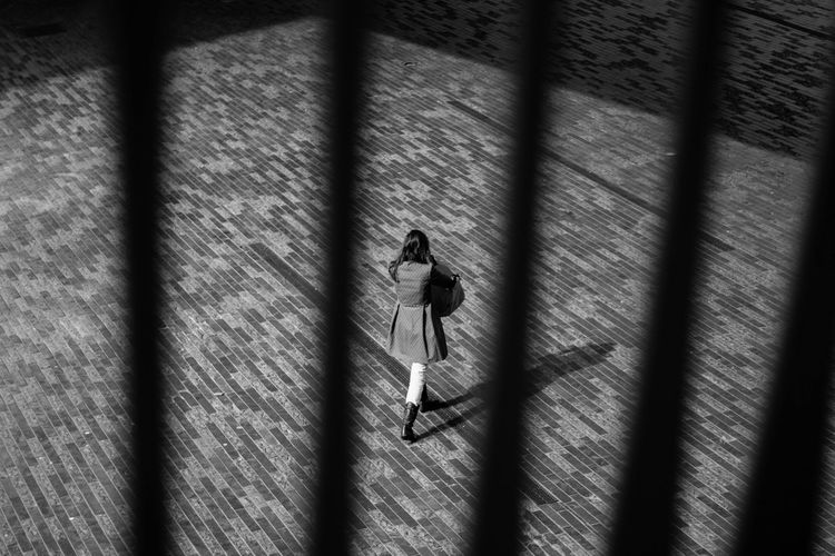 High angle view of woman walking on zebra crossing
