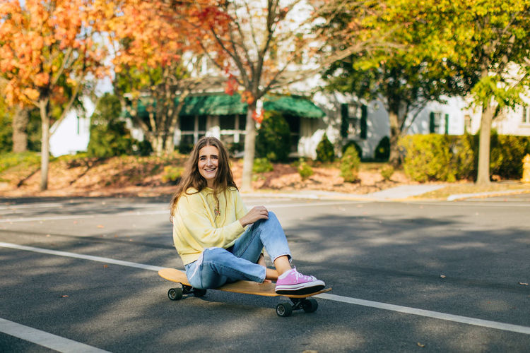 Portrait of teenage girl sitting on road