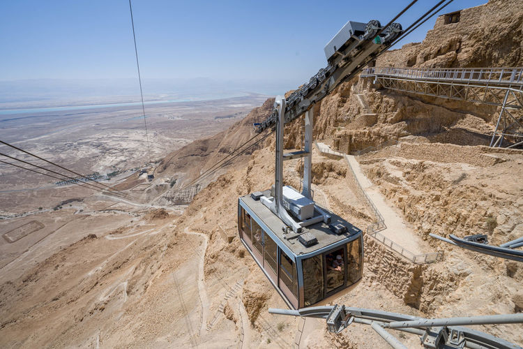 Yellow cableway start descent from masada fortress on sunny day israel
