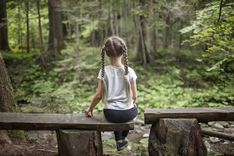 Full length of girl standing on wood in forest