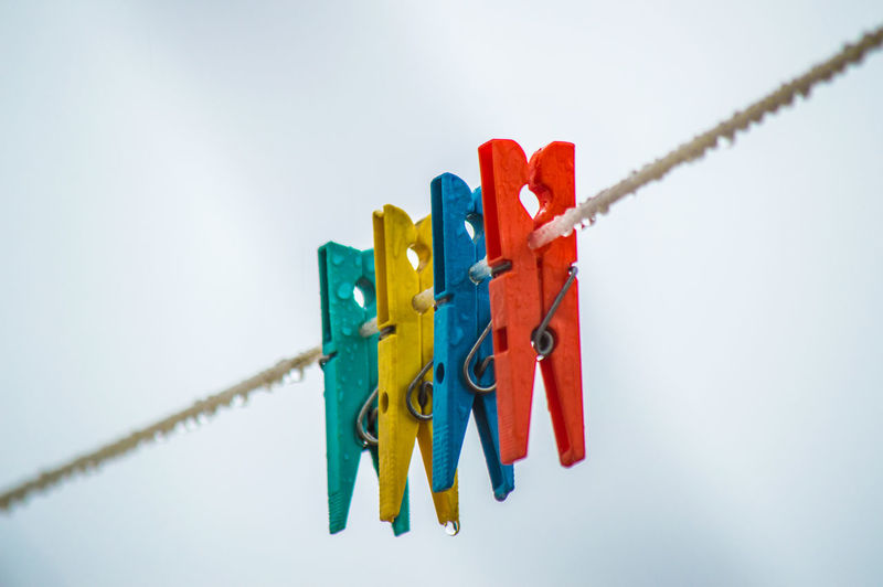 Low angle view of clothespins on rope
