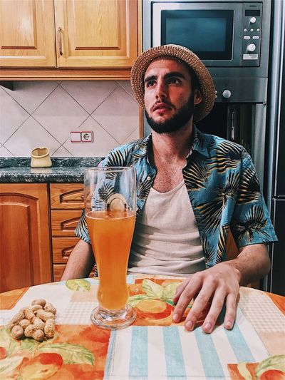 Man with drink in kitchen
