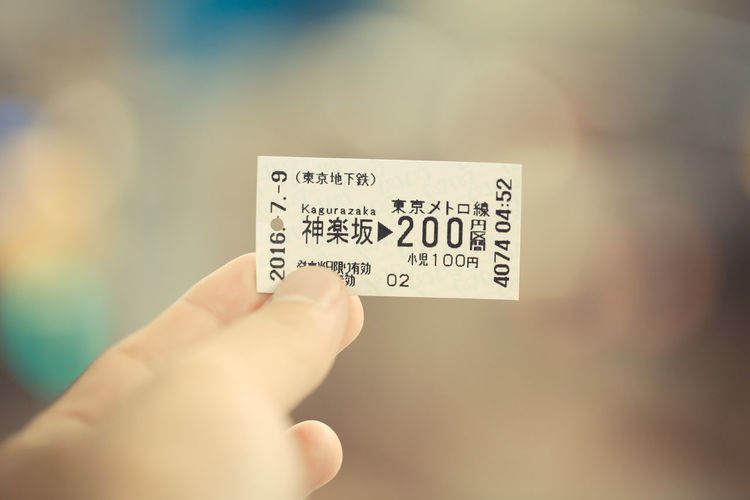 Cropped image of person holding train ticket