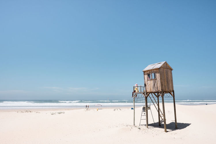 Lifeguard hut on beach against sky