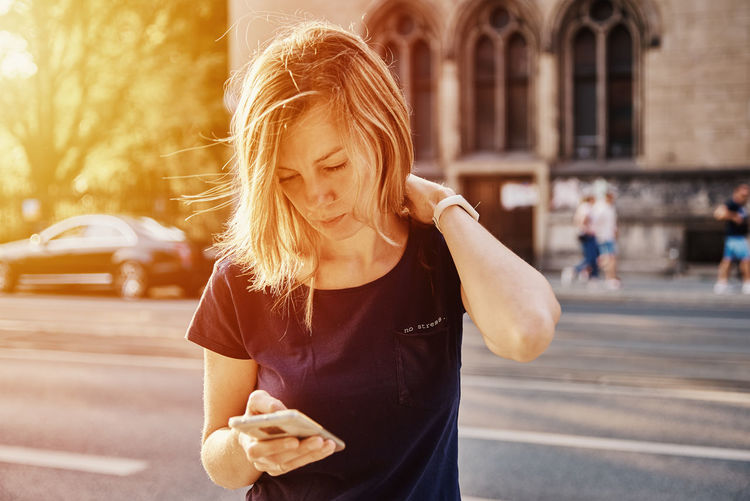 Woman using smartphone at city street