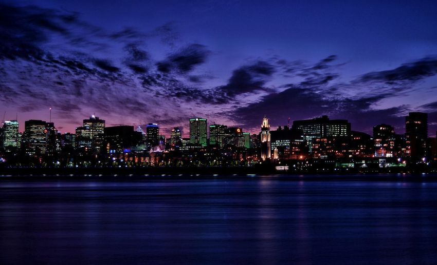 Illuminated city by st lawrence river against sky at night