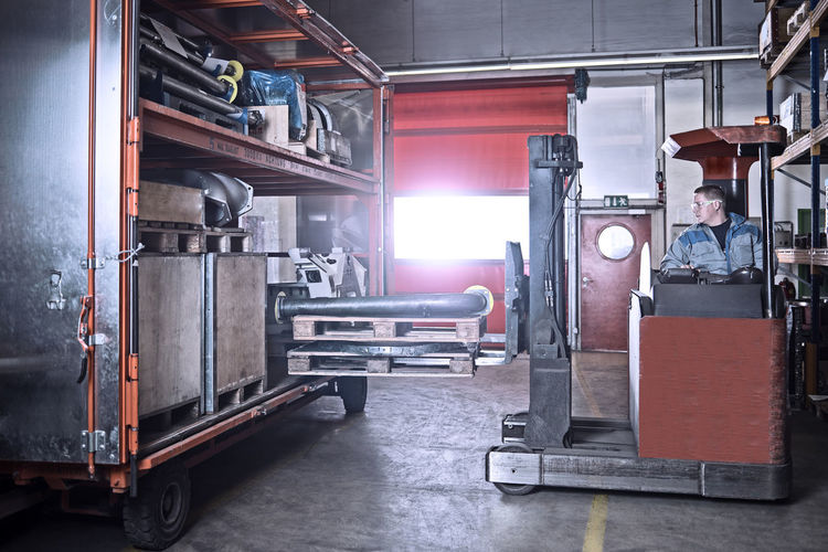 Fork-lift driver loading trailer