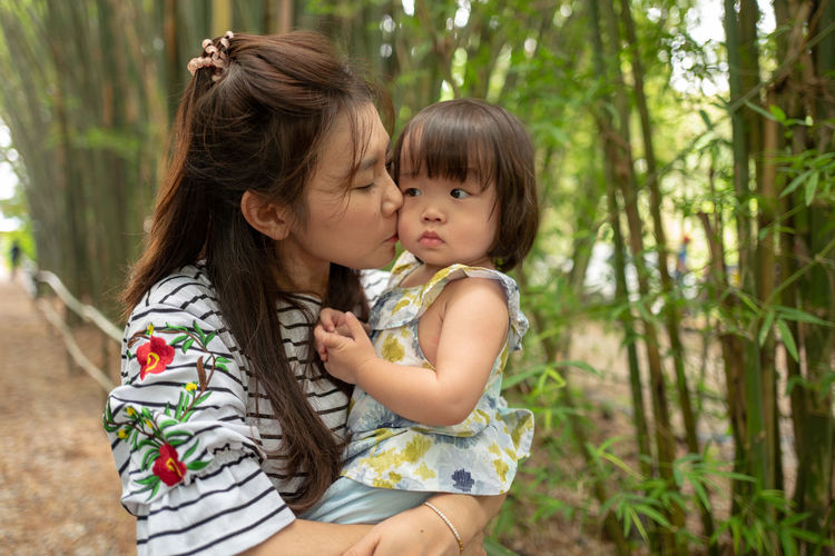 Mother kissing cute daughter