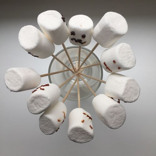 Close-up view of marshmallows in container on white background