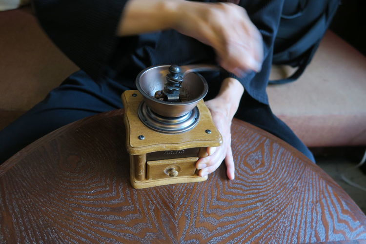 High angle view of person grinding coffee on table