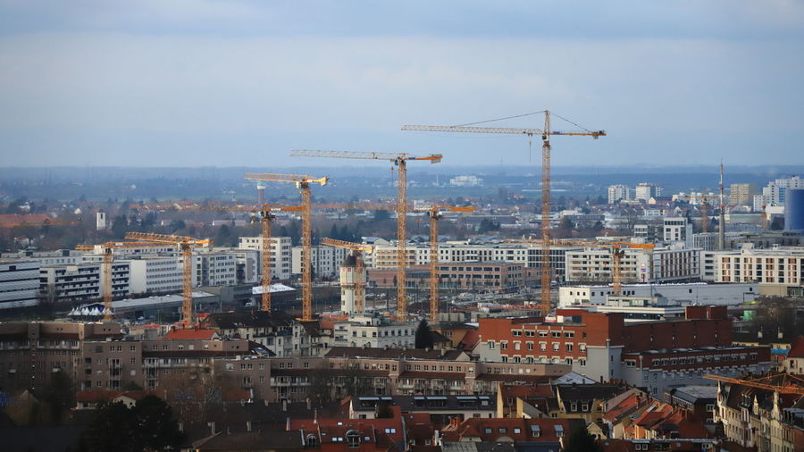 Aerial view of buildings in city against sky