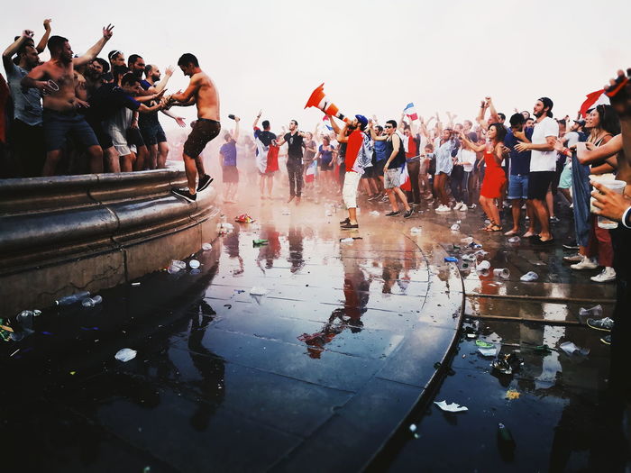 People celebrating festival in city against sky