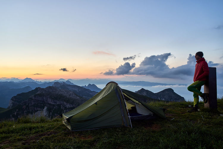 Tent on mountain against sky during sunset
