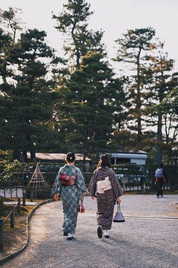 Rear view of women in kimonos walking on street
