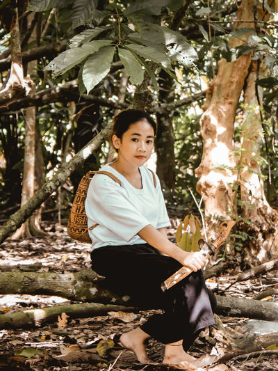 Portrait of woman sitting in forest