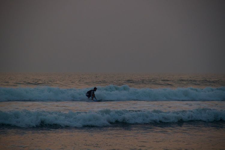 Man is serfing against clear sky during sunset in goa
