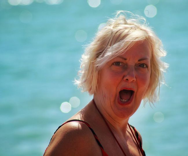 Portrait of woman screaming against sea