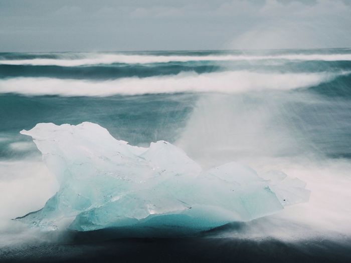 View of waves crashing on iceberg at sea