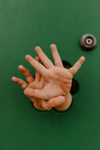Cropped hand of woman holding pills against blue background