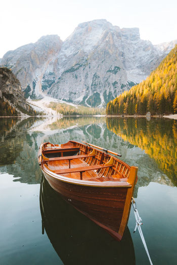 Boat moored on lake by mountain