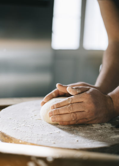 Cropped hand of person preparing food in kitchen