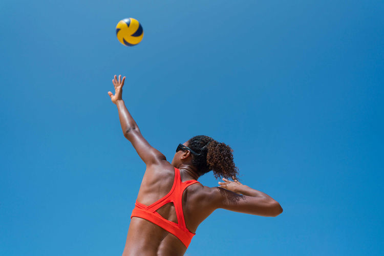 Woman with afro hair playing beach volleyball