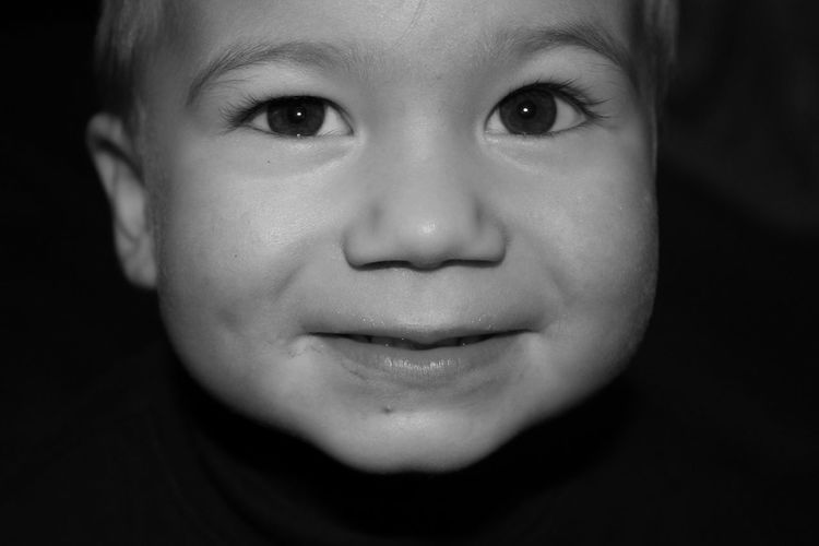 Close-up portrait of baby boy against black background