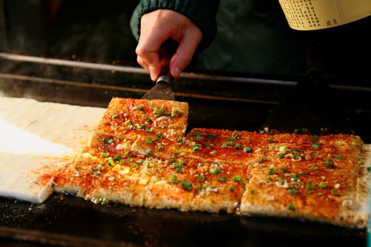 Close-up of hand preparing pizza