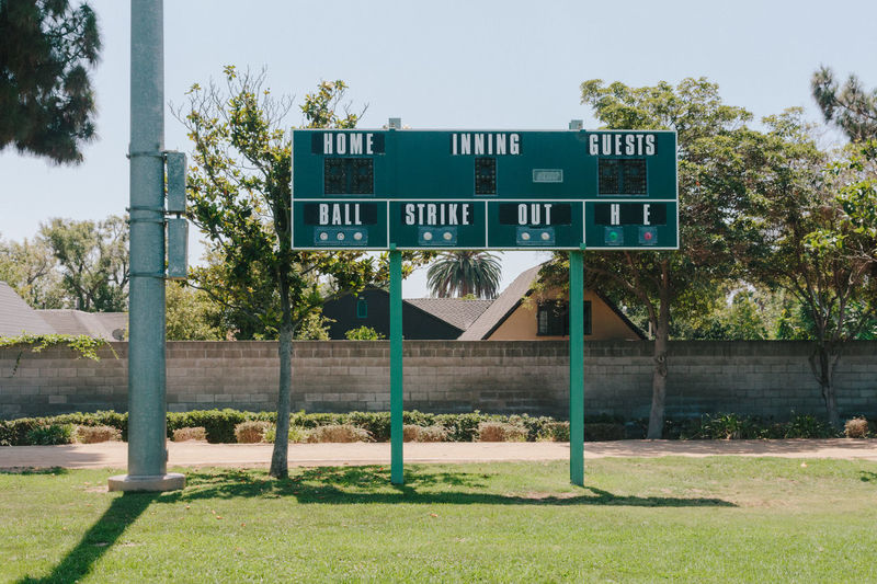 Scoreboard on baseball field against sky