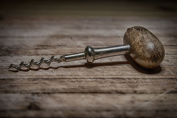 Close-up of corkscrew on wood table