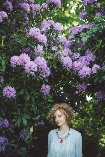 Woman standing against purple flowering plants