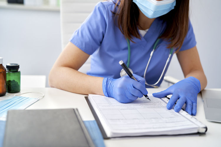 Midsection of doctor working at table